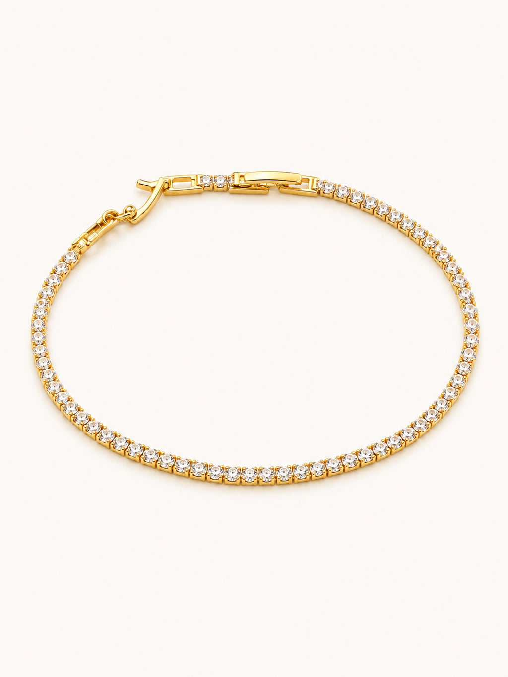 Classic Tennis Bracelet in 18K gold plated stainless steel featuring a continuous row of brilliant round white CZ stones with a secure box clasp.