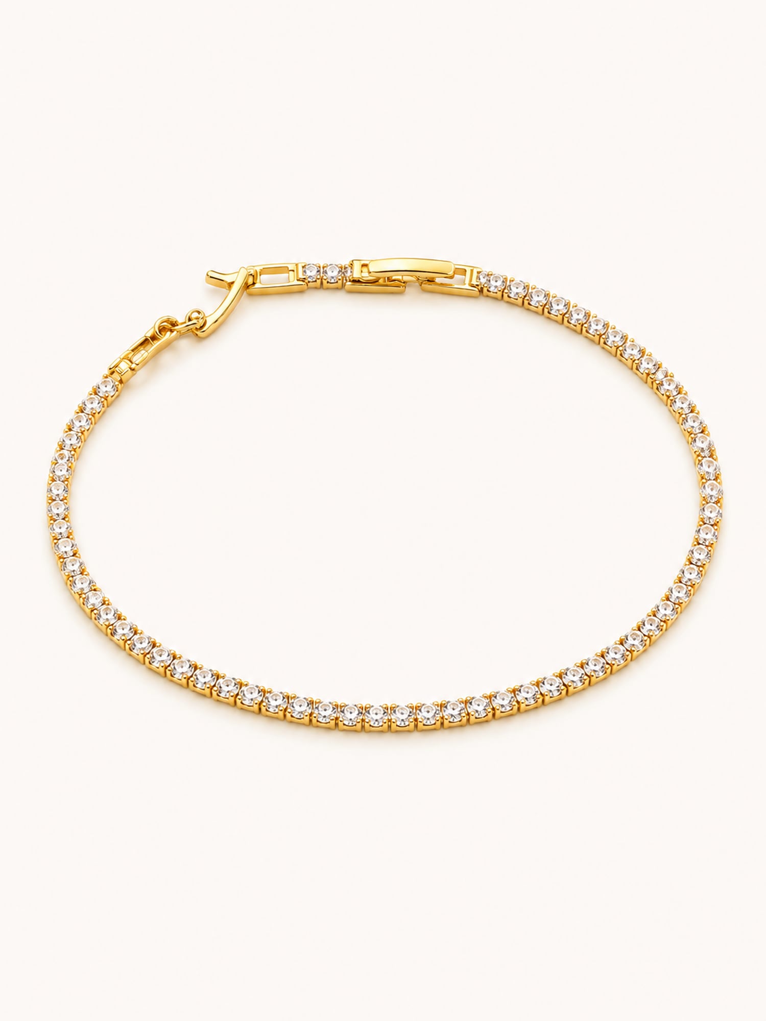 Classic Tennis Bracelet in 18K gold plated stainless steel featuring a continuous row of brilliant round white CZ stones with a secure box clasp.