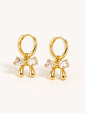 Crystal bow huggie earrings with clear cubic zirconia in polished gold finish.