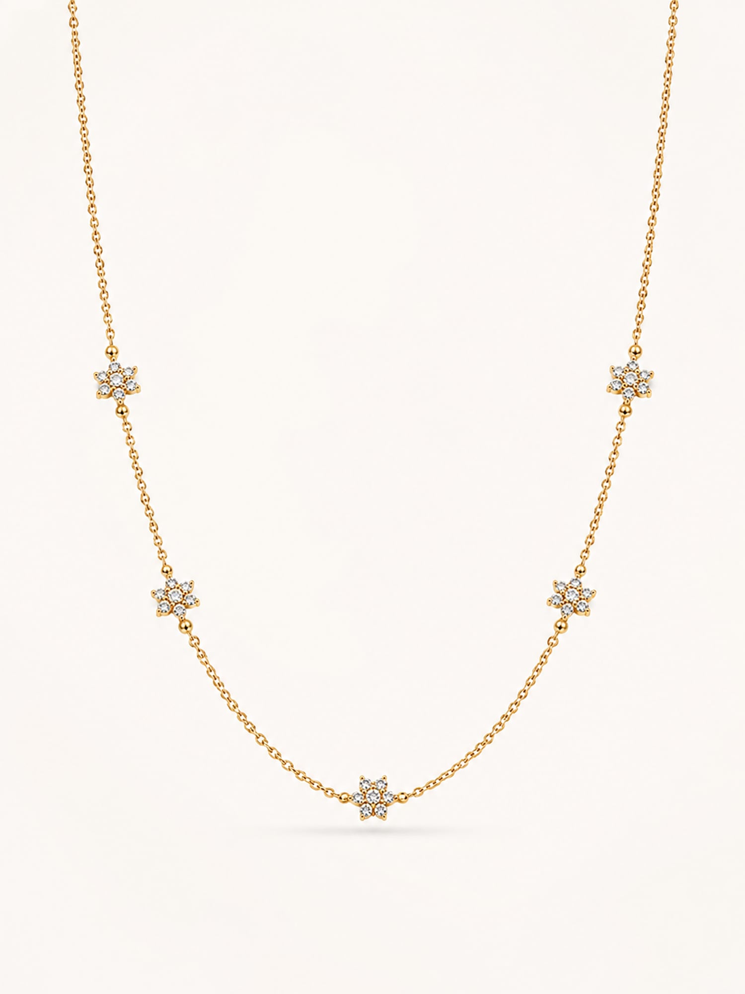 Floral CZ station necklace in 18K gold plated stainless steel featuring five sparkling flower motifs on a delicate chain.