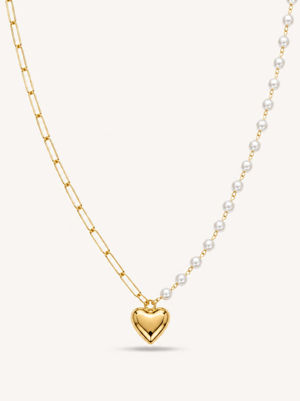 Asymmetrical heart pendant necklace featuring a paperclip chain and faux pearl chain in 18K gold finish.