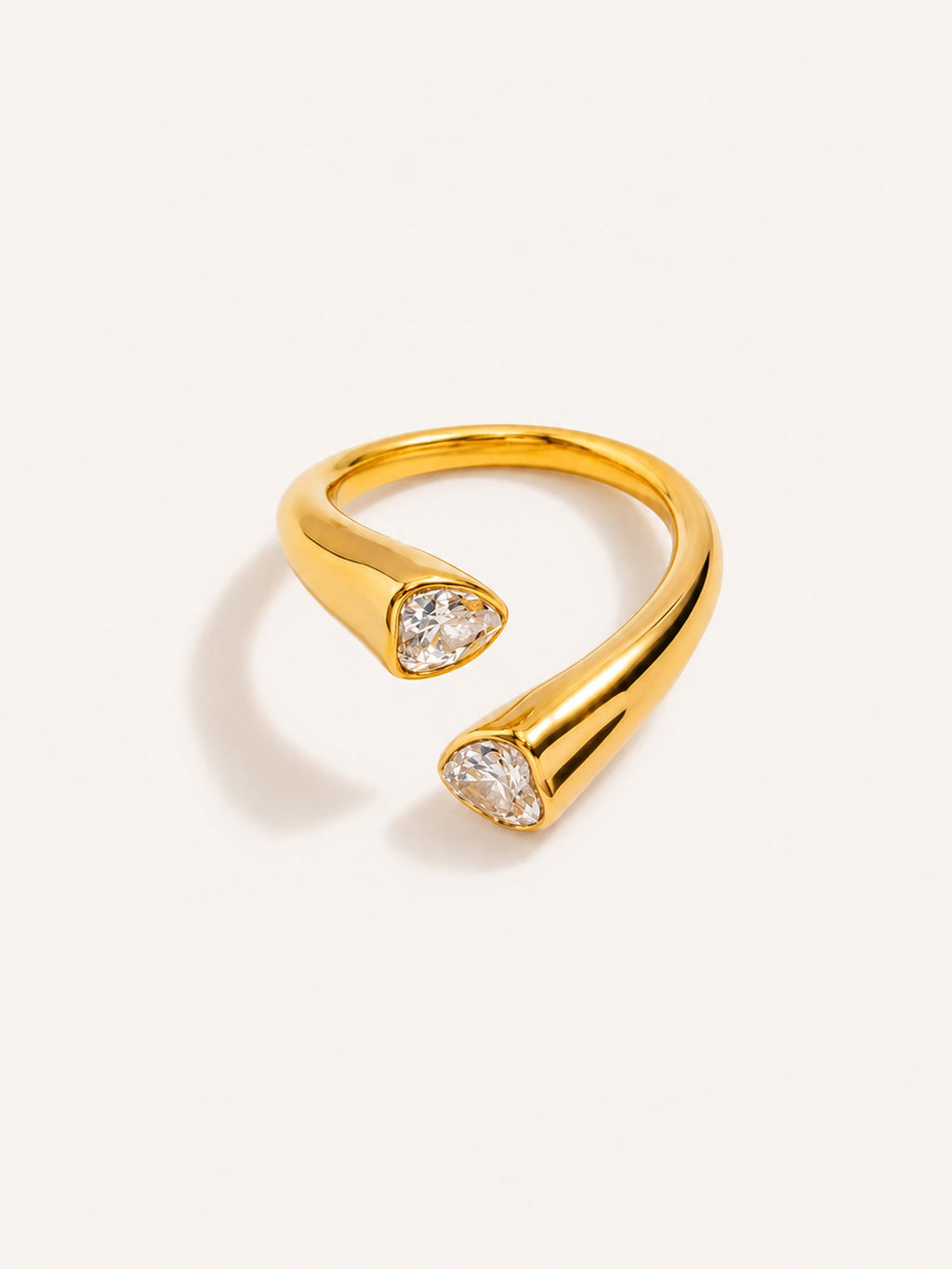Pear cut open ring featuring two white CZ stones in a polished gold finish.