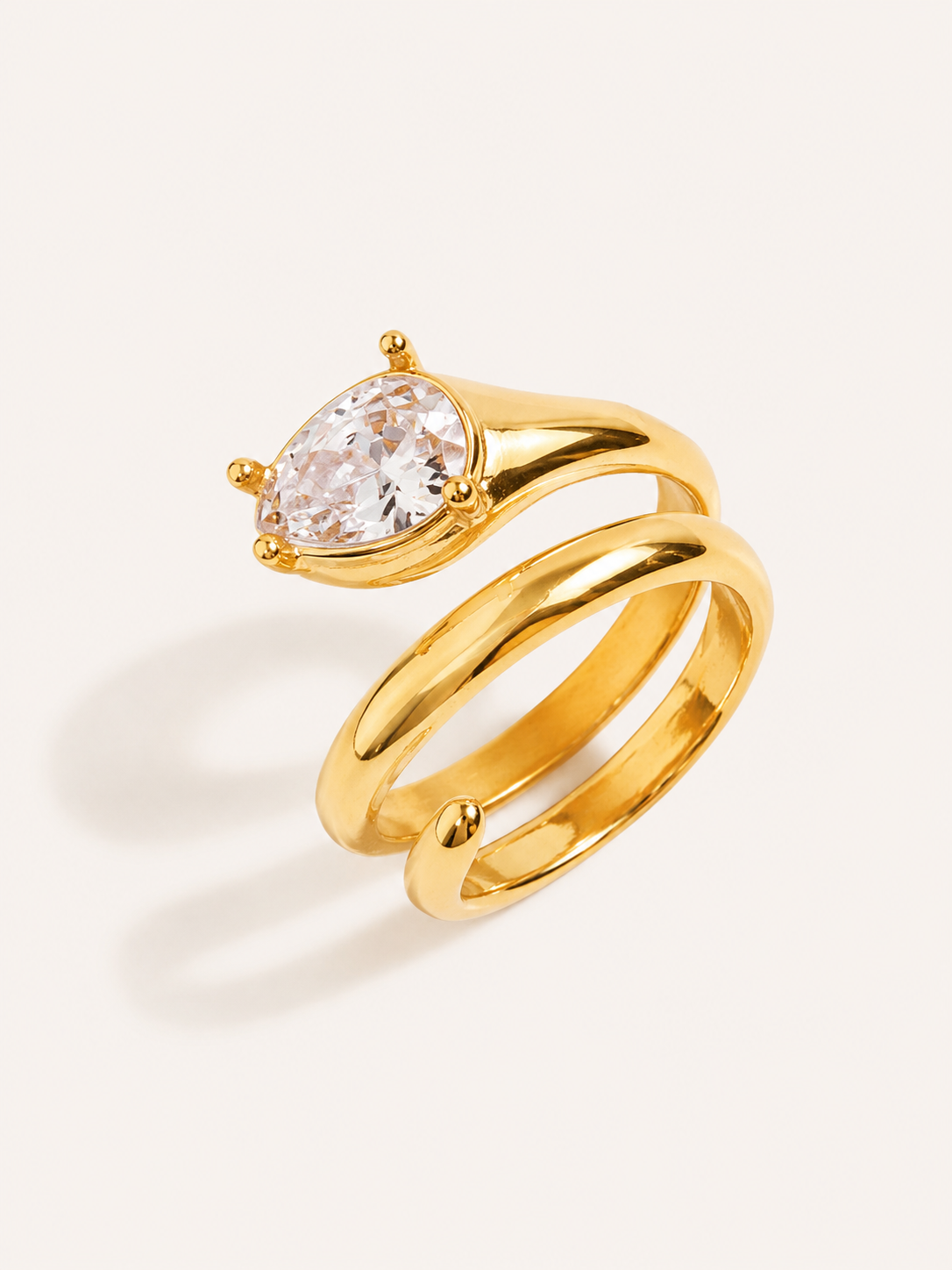 Pear cut wrap ring with a sparkling white CZ stone in a polished gold finish.